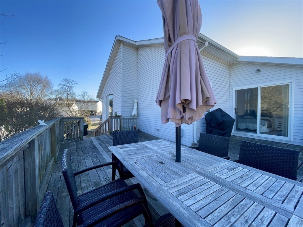 15 Burghardt Street, Unit B Worcester, MA 01604 - Photo 30 of 30 a view of a roof deck with dining table and chair with wooden floor