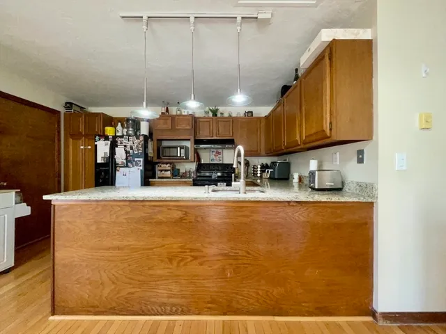 a view of a living room with kitchen furniture and a fireplace