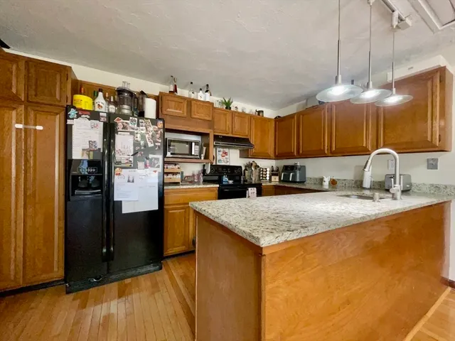 a kitchen with stainless steel appliances granite countertop a sink a stove and a refrigerator