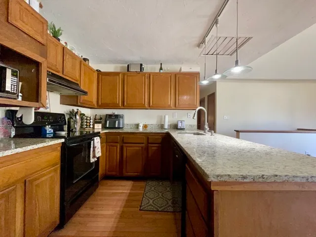 a kitchen with stainless steel appliances granite countertop a sink stove and cabinets