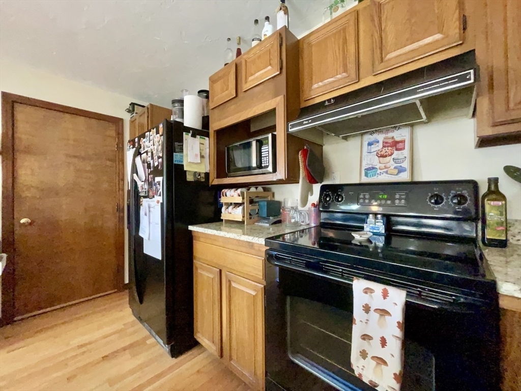 15 Burghardt Street, Unit B Worcester, MA 01604 - Photo 10 of 30 a kitchen with stainless steel appliances granite countertop a stove and a refrigerator