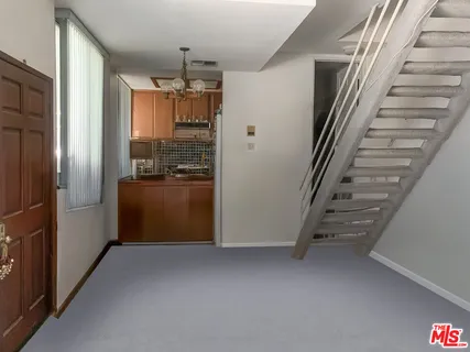 a view of hallway with stairs and wooden floor