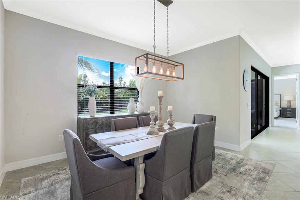 2134 Antigua Lane Naples, FL 34120 - Photo 11 of 31 a dining room with furniture a chandelier and window