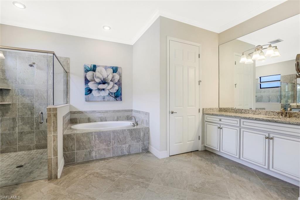 2134 Antigua Lane Naples, FL 34120 - Photo 15 of 31 a bathroom with a granite countertop sink a bathtub and a shower
