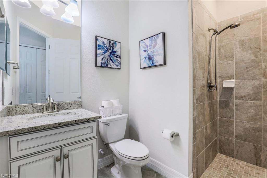2134 Antigua Lane Naples, FL 34120 - Photo 17 of 31 a bathroom with a granite countertop toilet a sink and a mirror
