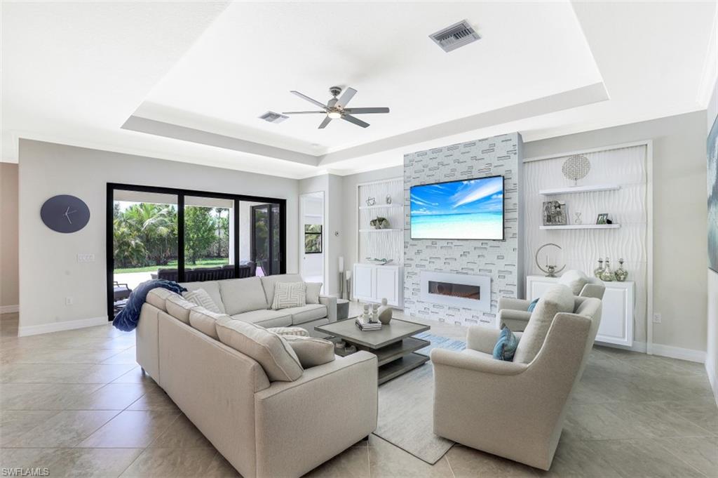 2134 Antigua Lane Naples, FL 34120 - Photo 5 of 31 a living room with furniture a large window and a fireplace
