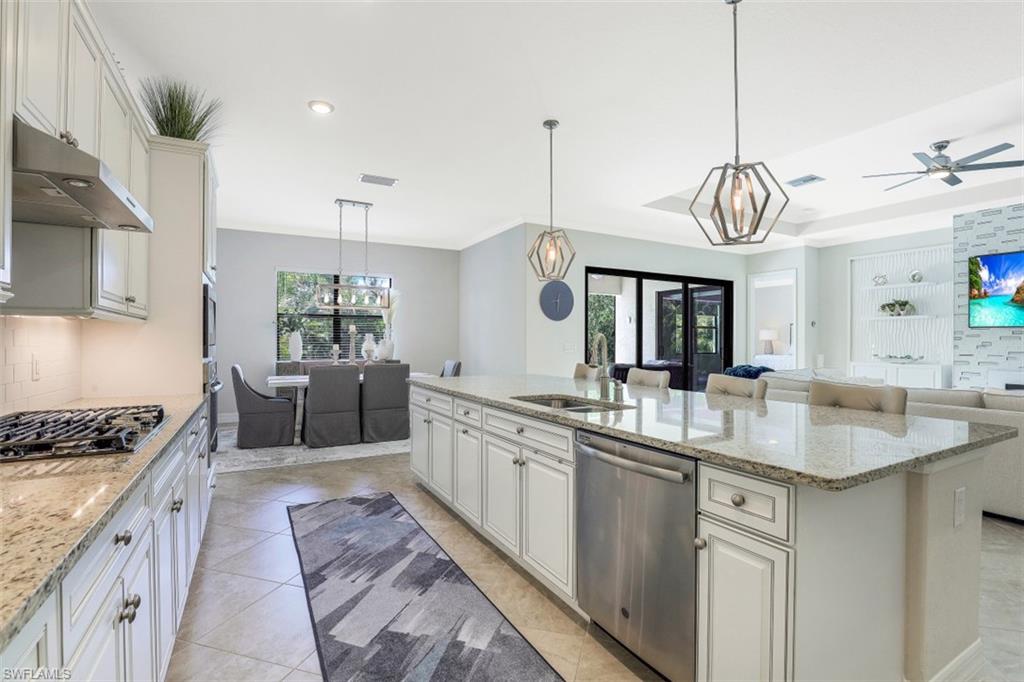2134 Antigua Lane Naples, FL 34120 - Photo 6 of 31 a kitchen with kitchen island granite countertop a sink a counter space appliances and cabinets