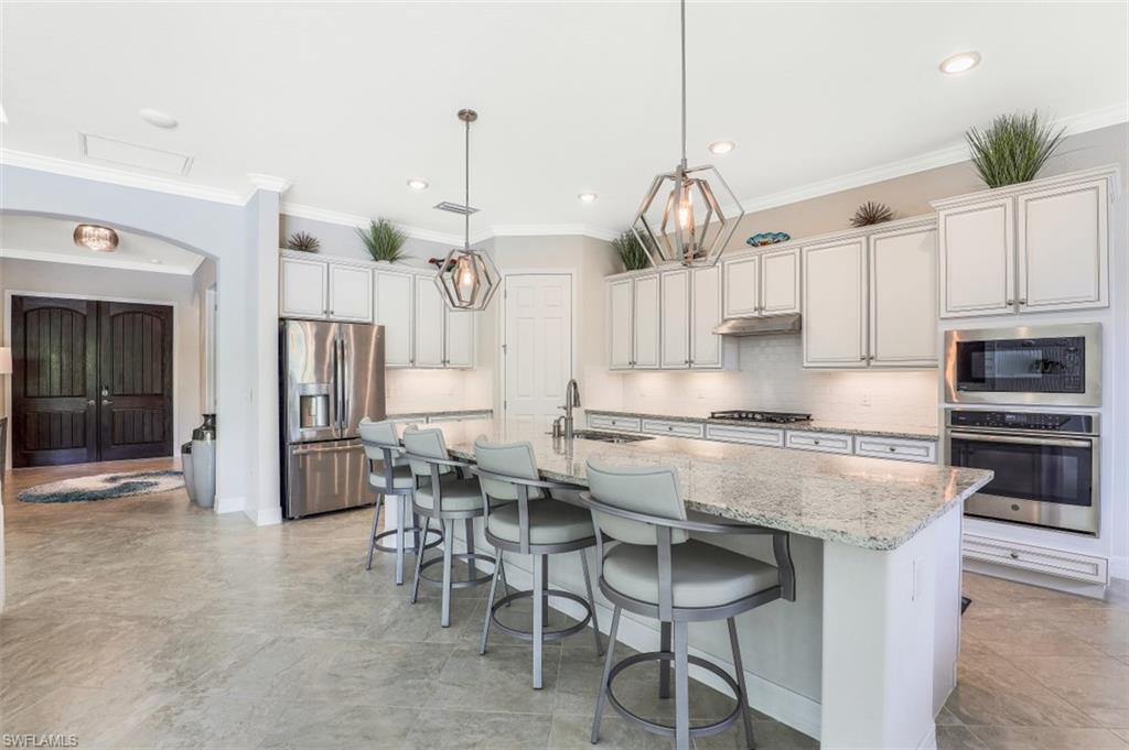 2134 Antigua Lane Naples, FL 34120 - Photo 8 of 31 a kitchen with stainless steel appliances granite countertop a stove oven and a refrigerator