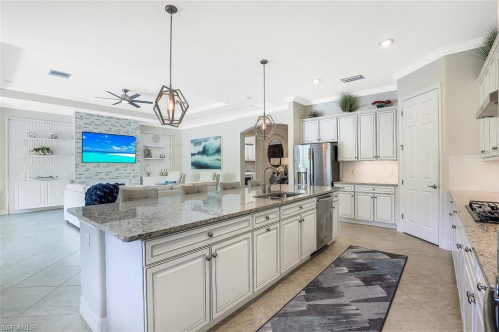 2134 Antigua Lane Naples, FL 34120 - Photo 9 of 31 a kitchen with stainless steel appliances granite countertop a sink a stove and a refrigerator