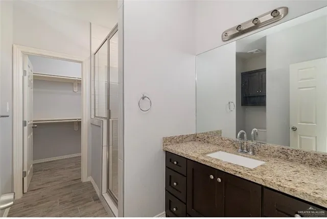 a bathroom with a granite countertop sink and a mirror