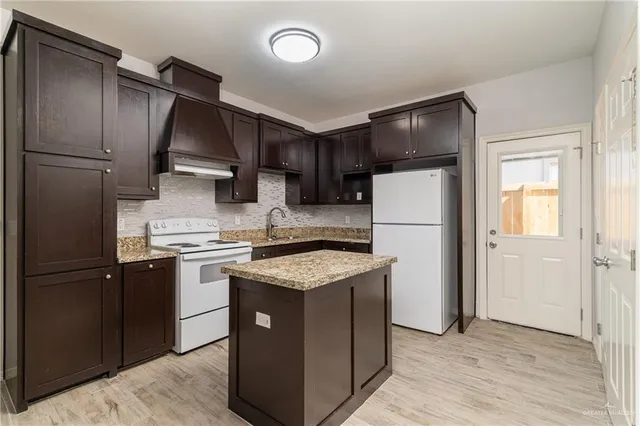 a kitchen with stainless steel appliances granite countertop a refrigerator stove a sink and dishwasher
