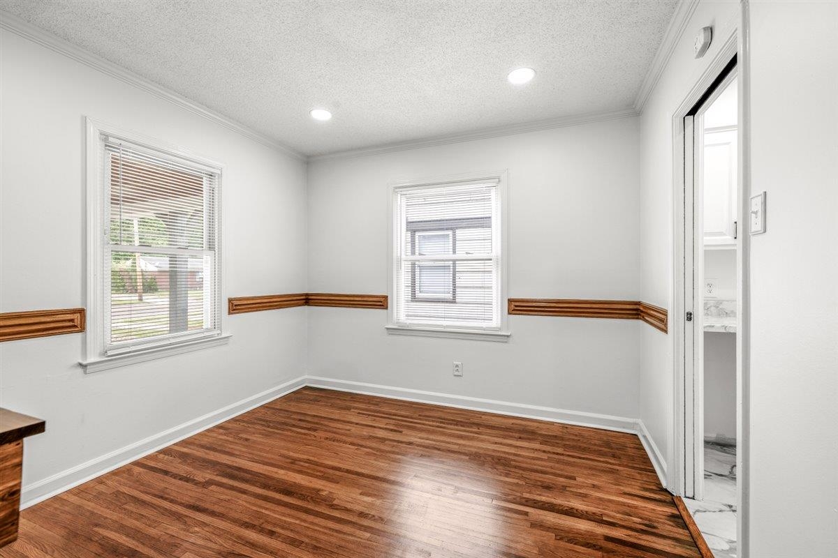 1244 Wells Station Road Memphis, TN 38122 - Photo 18 of 36 Unfurnished room with dark wood finished floors, a textured ceiling, recessed lighting, and crown molding