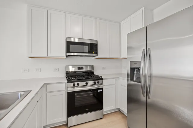 a kitchen with cabinets stainless steel appliances and a sink