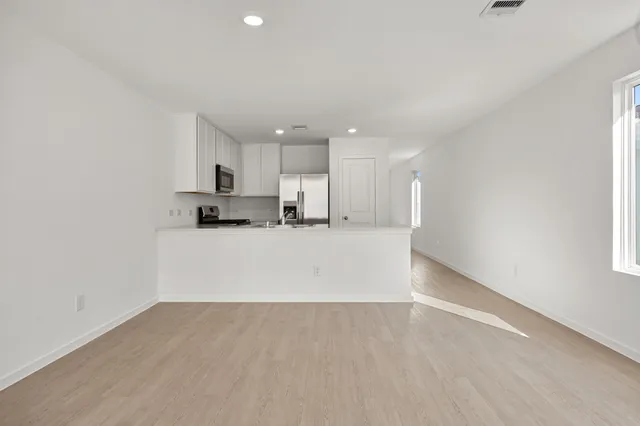 a view of kitchen with refrigerator and window
