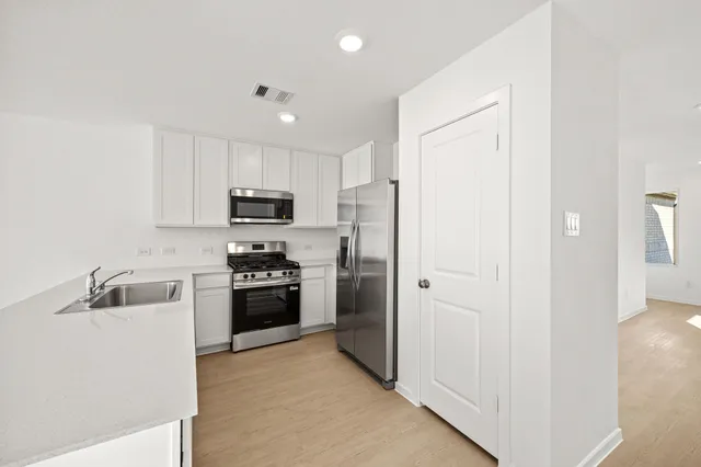 a kitchen with granite countertop stainless steel appliances and refrigerator