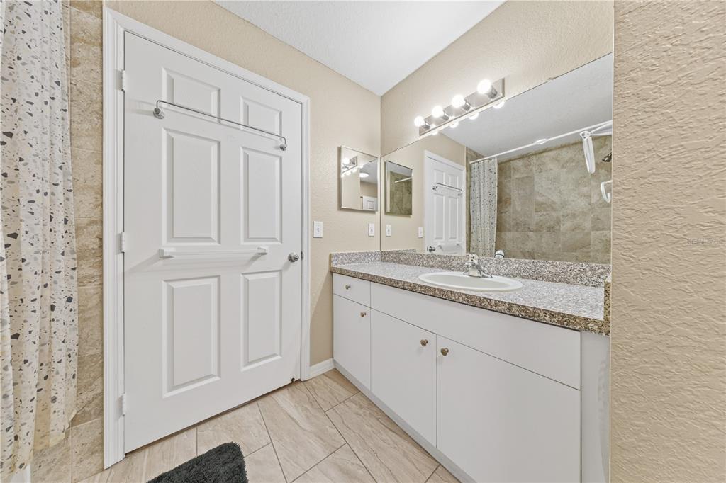 6340 Raleigh Street, Unit 1011 Orlando, FL 32835 - Photo 31 of 68 a bathroom with a granite countertop sink and a mirror