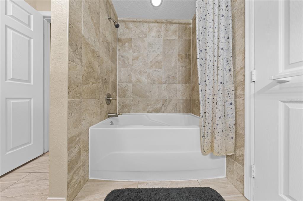 6340 Raleigh Street, Unit 1011 Orlando, FL 32835 - Photo 32 of 68 a bathroom with a white bath tub