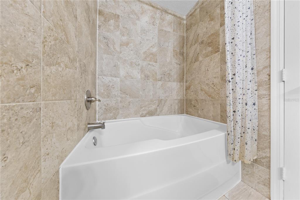 6340 Raleigh Street, Unit 1011 Orlando, FL 32835 - Photo 33 of 68 a white bath tub sitting next to a shower