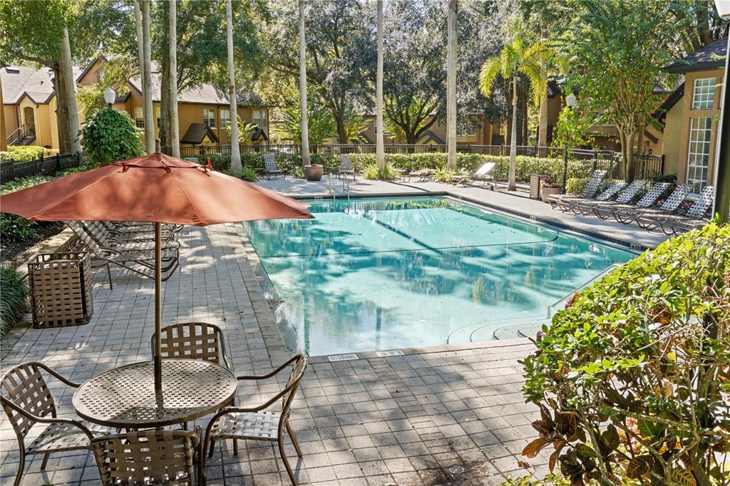 6340 Raleigh Street, Unit 1011 Orlando, FL 32835 - Photo 58 of 68 a patio with a table and chairs under an umbrella