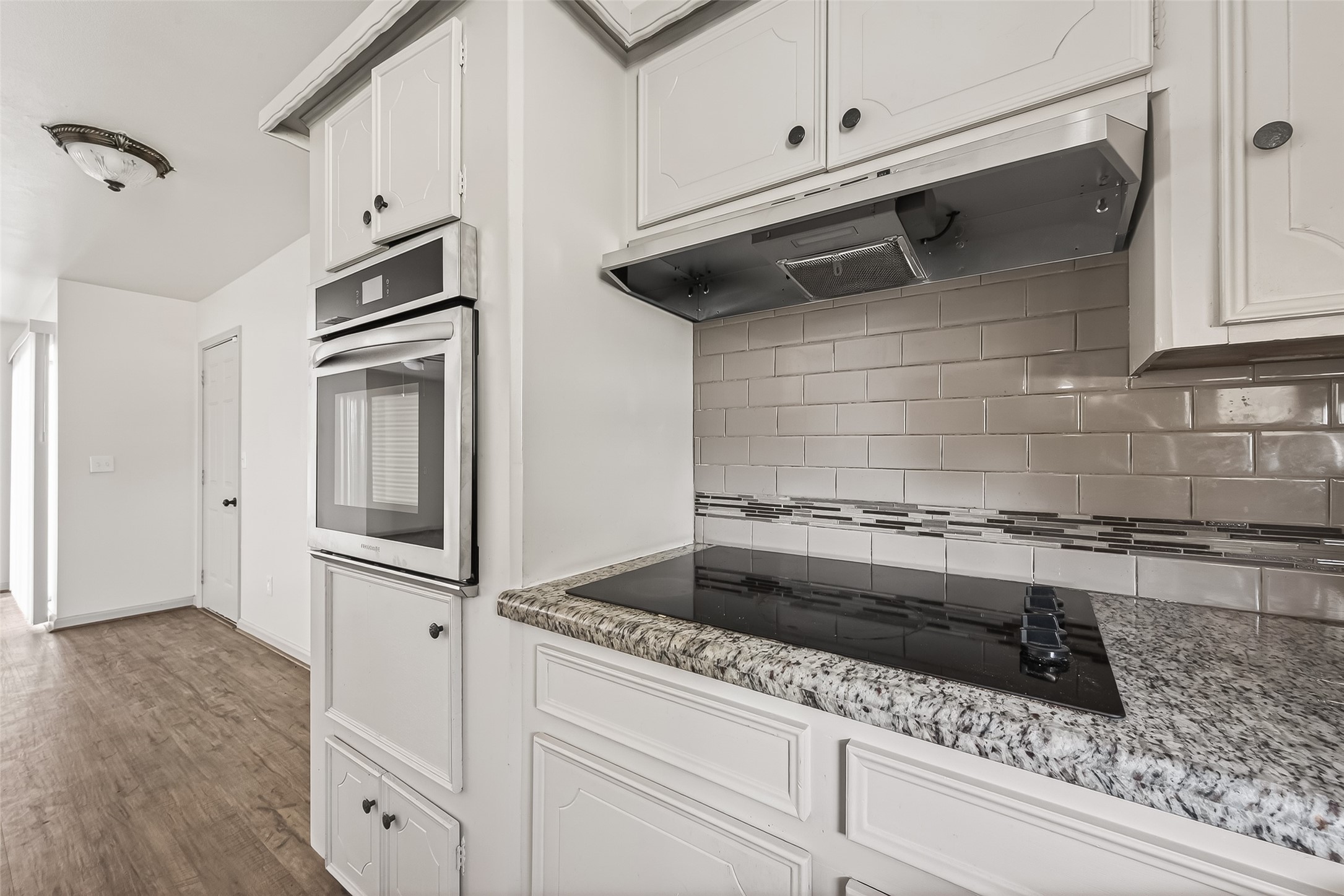 10503 Ladino Road Cypress, TX 77429 - Photo 8 of 21 Updated kitchen featuring granite countertops, subway tile backsplash, glass cooktop, and a new oven.