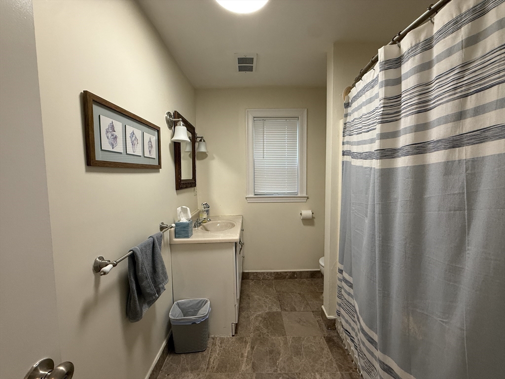 106 Chester Street, Unit 2 Boston, MA 02134 - Photo 8 of 9 a bathroom with a sink and mirror with toilet