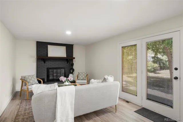 a living room with furniture a fireplace and a floor to ceiling window