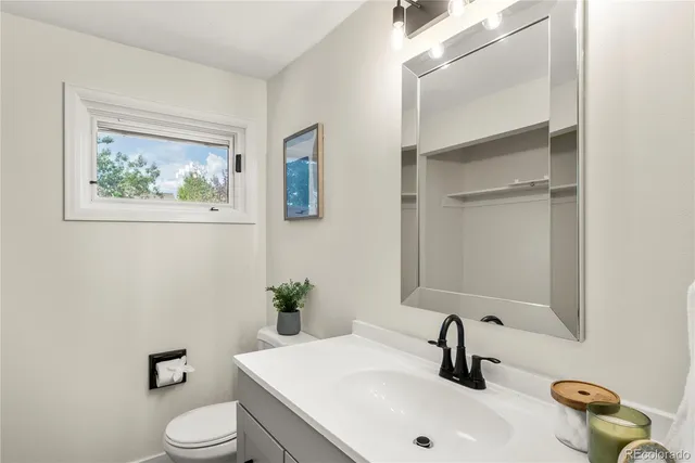 a bathroom with a sink mirror and toilet