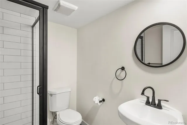 a bathroom with a toilet a sink and a mirror