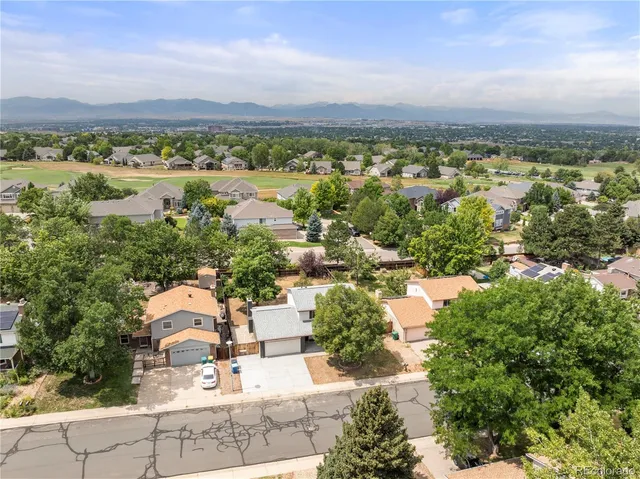 an aerial view of residential houses with outdoor space and trees