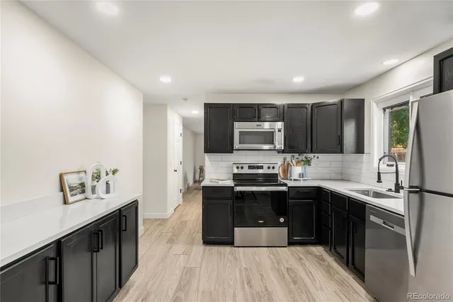a kitchen with stainless steel appliances a sink stove and refrigerator