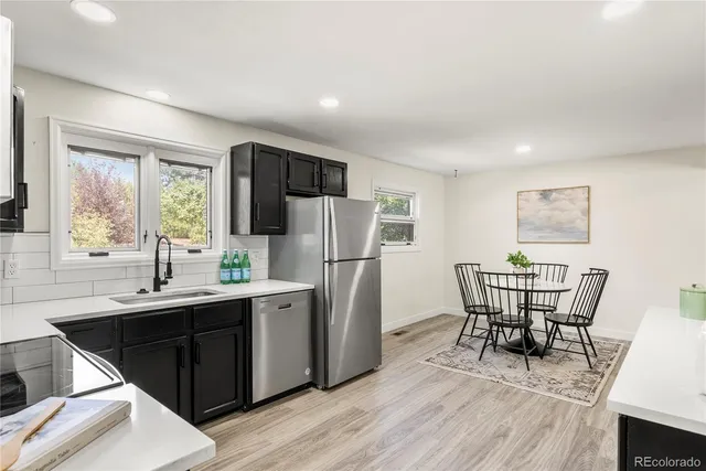 a dining room with stainless steel appliances a dining table and chairs