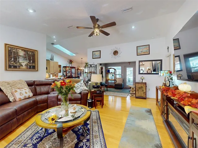 a living room with furniture kitchen view and a window