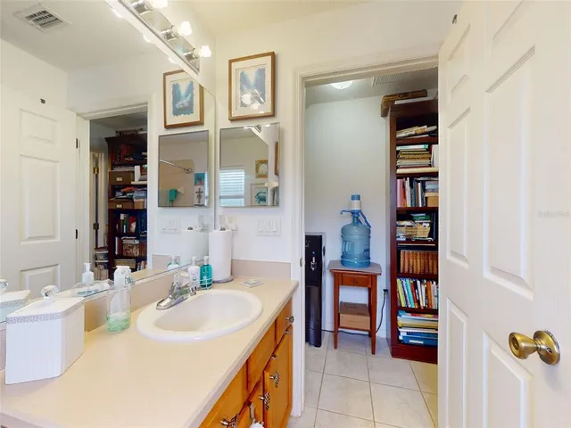 a view of a patio with table and chairs potted plants and floor to ceiling window