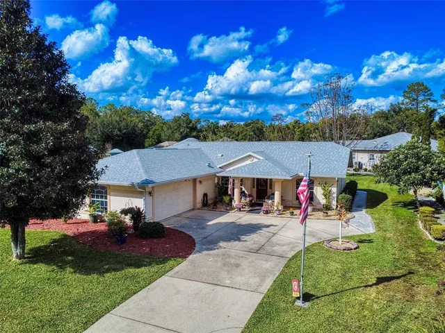 a front view of a house with a yard and potted plants