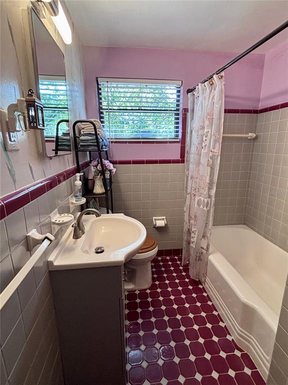 3137 Northwest 6th Street Gainesville, FL 32609 - Photo 6 of 11 a bathroom with a sink a toilet a tub and shower