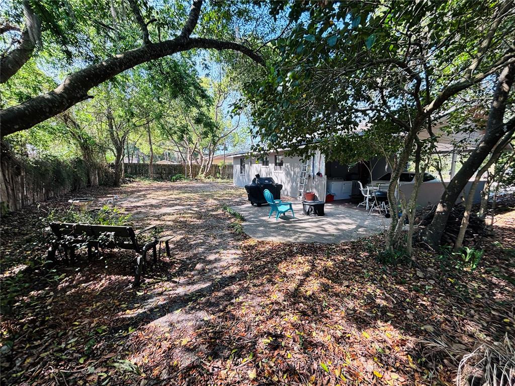 3137 Northwest 6th Street Gainesville, FL 32609 - Photo 10 of 11 a view of a backyard with table and chairs under a large tree