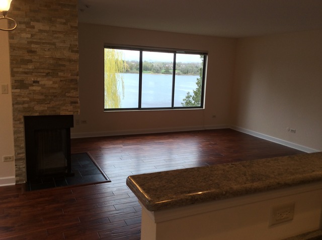 305 Shoreline Road, Unit 305 Lake Barrington, IL 60010 - Photo 18 of 23 an empty room with wooden floor and windows