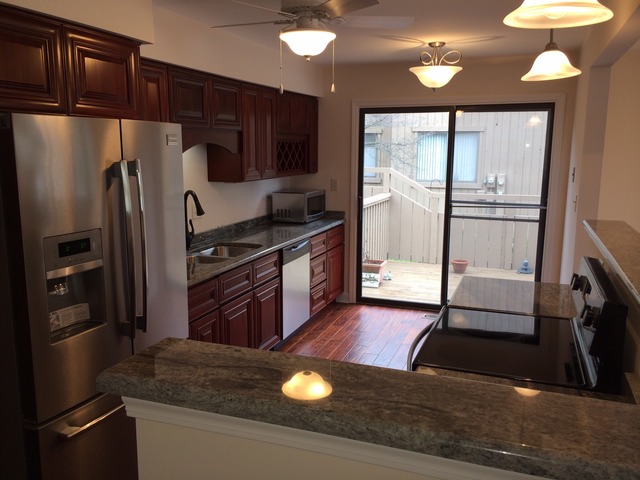 305 Shoreline Road, Unit 305 Lake Barrington, IL 60010 - Photo 4 of 23 a kitchen with stainless steel appliances granite countertop a refrigerator a stove and a sink with wooden floor