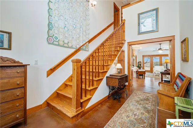 a kitchen with stainless steel appliances granite countertop a refrigerator a stove top oven a sink dishwasher and white cabinets with wooden floor