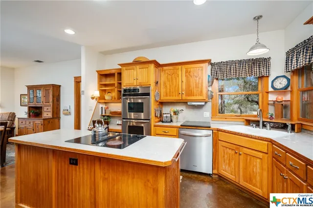 a kitchen with stainless steel appliances granite countertop refrigerator sink and stove