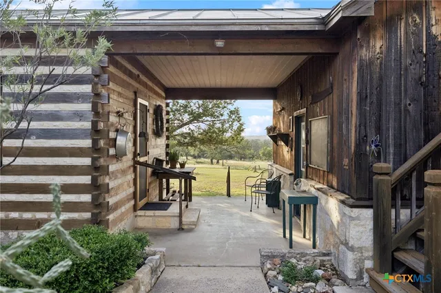 a view of a house with a yard and a large tree