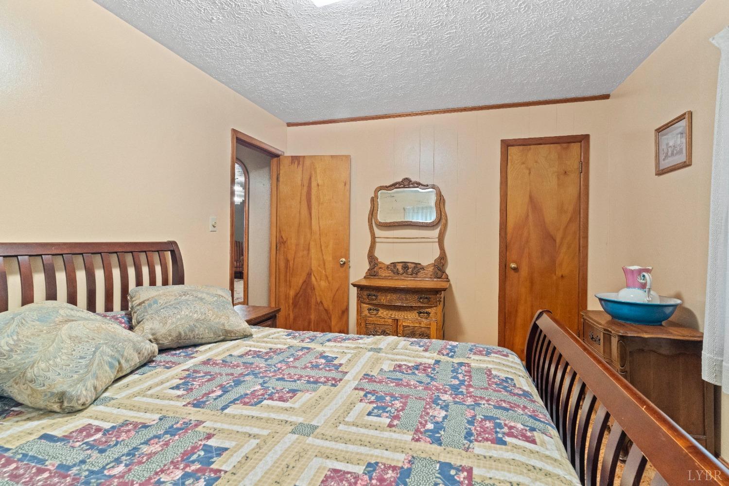 2550 Pamplin Road Pamplin, VA 23958 - Photo 7 of 35 a bedroom with a bed and dresser with mirror