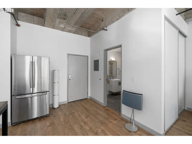 a kitchen with stainless steel appliances refrigerator and wooden floor