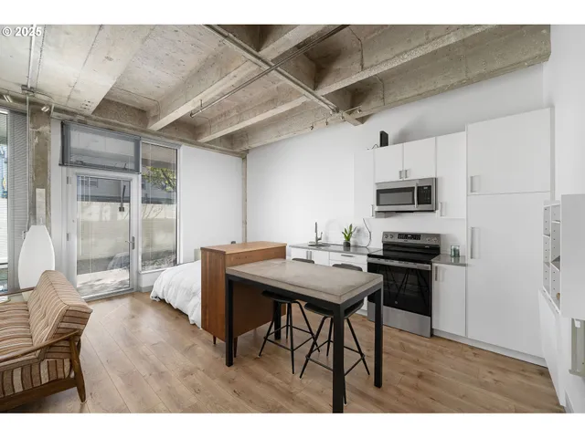 a kitchen with stainless steel appliances kitchen island a table chairs and wooden floor
