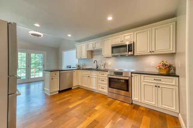a kitchen with granite countertop a stove top oven sink and cabinets