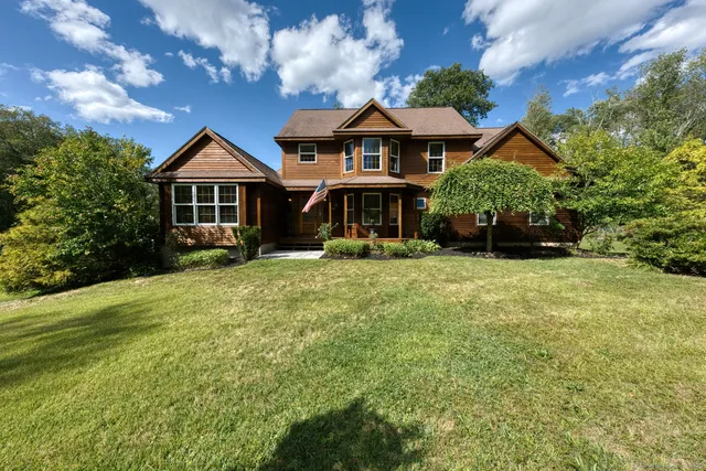 a front view of a house with yard and green space