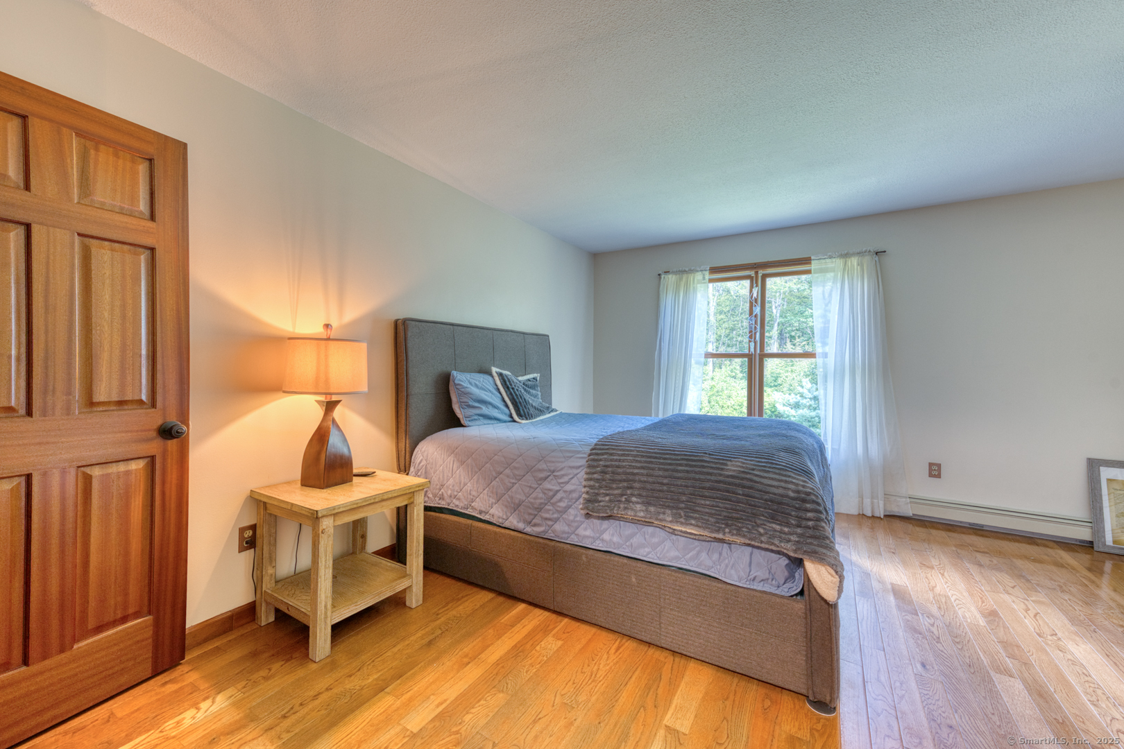 287 South Bear Hill Road Chaplin, CT 06235 - Photo 26 of 40 a spacious bedroom with a bed and wooden floor