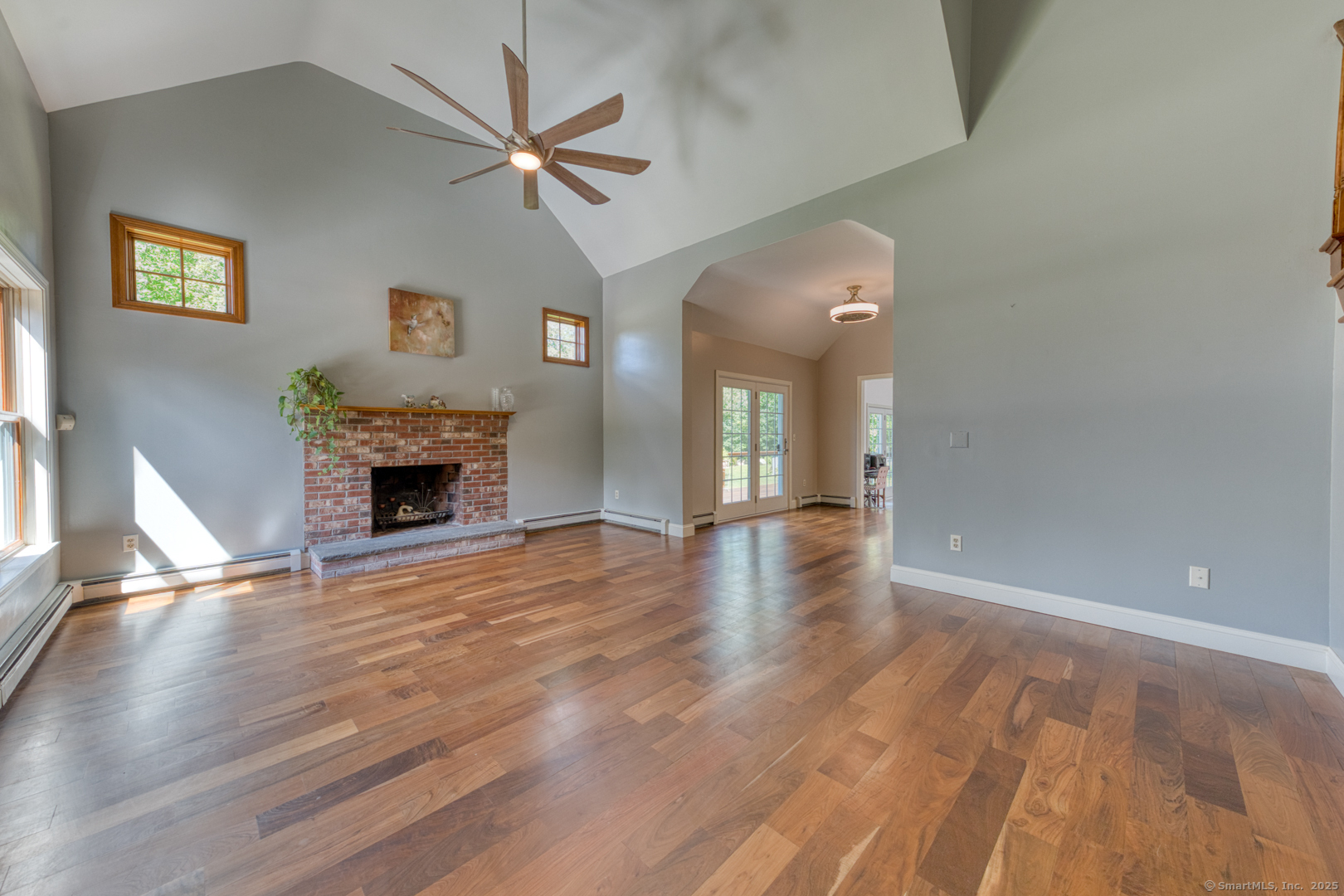 287 South Bear Hill Road Chaplin, CT 06235 - Photo 9 of 40 an empty room with wooden floor a fireplace and a ceiling fan