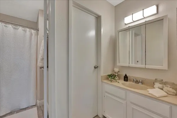 a bathroom with a granite countertop sink and a mirror