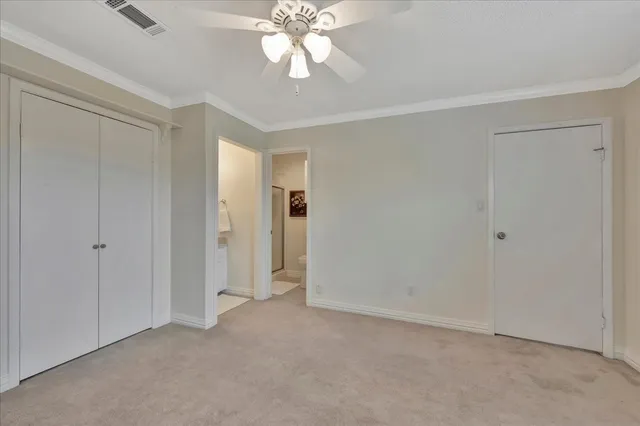 an empty room with windows and ceiling fan